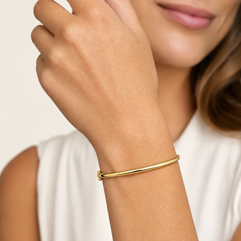 Bracelete liso em ouro 18k no pulso, em foto com modelo