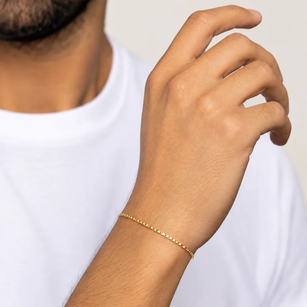 Pulseira piastrine fina em ouro 18k no pulso, em foto com modelo