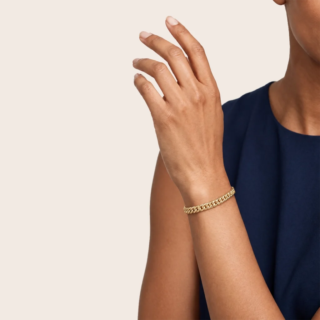 Pulseira romana longa em ouro 18k no pulso, em foto com modelo