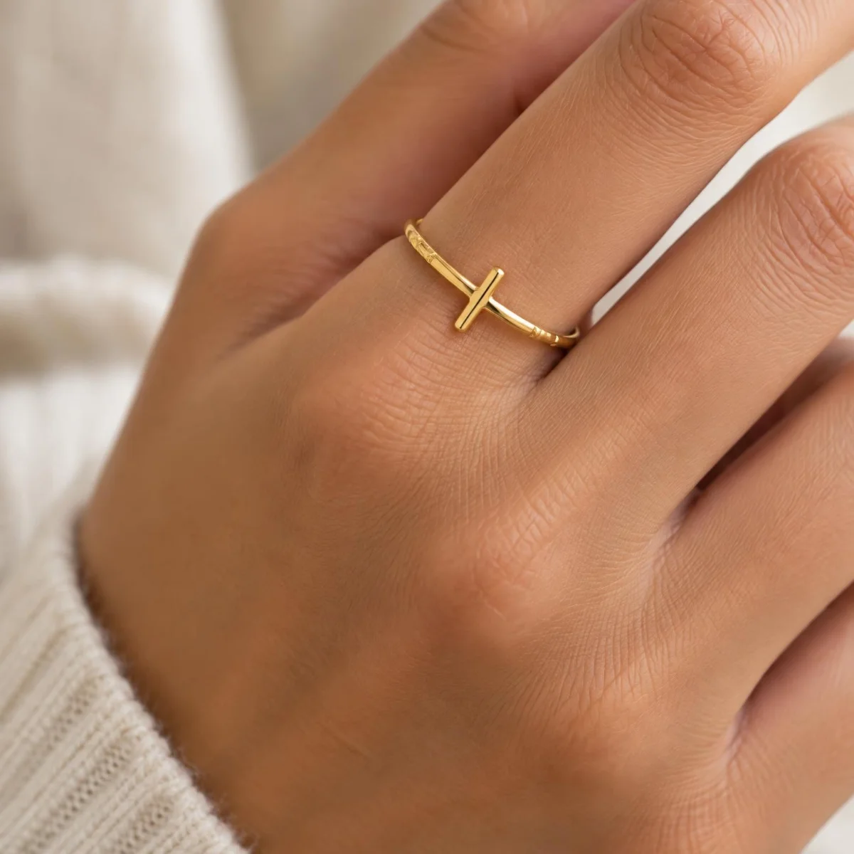 Anel com Cruz e Fé em Ouro 18k, na mão de uma modelo
