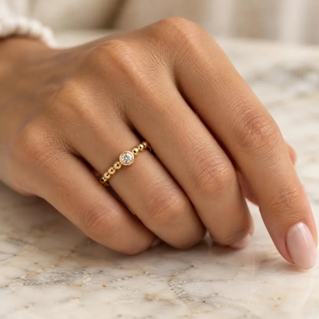 Anel Solitário Aro de Bolinhas em ouro 18k, na mão de uma modelo