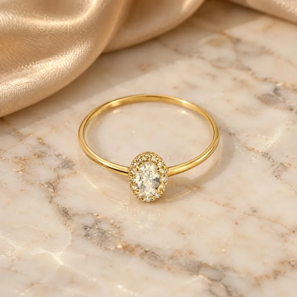 Anel Solitário Oval com Halo de Pedras em ouro 18k, em foto de estúdio