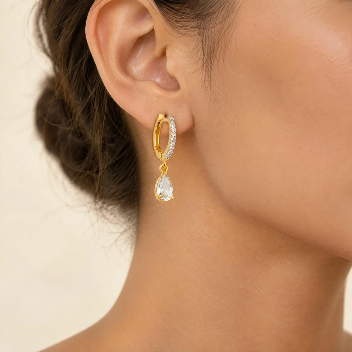 Brinco Argola com Pingente de Gota em ouro 18k, na orelha de uma modelo