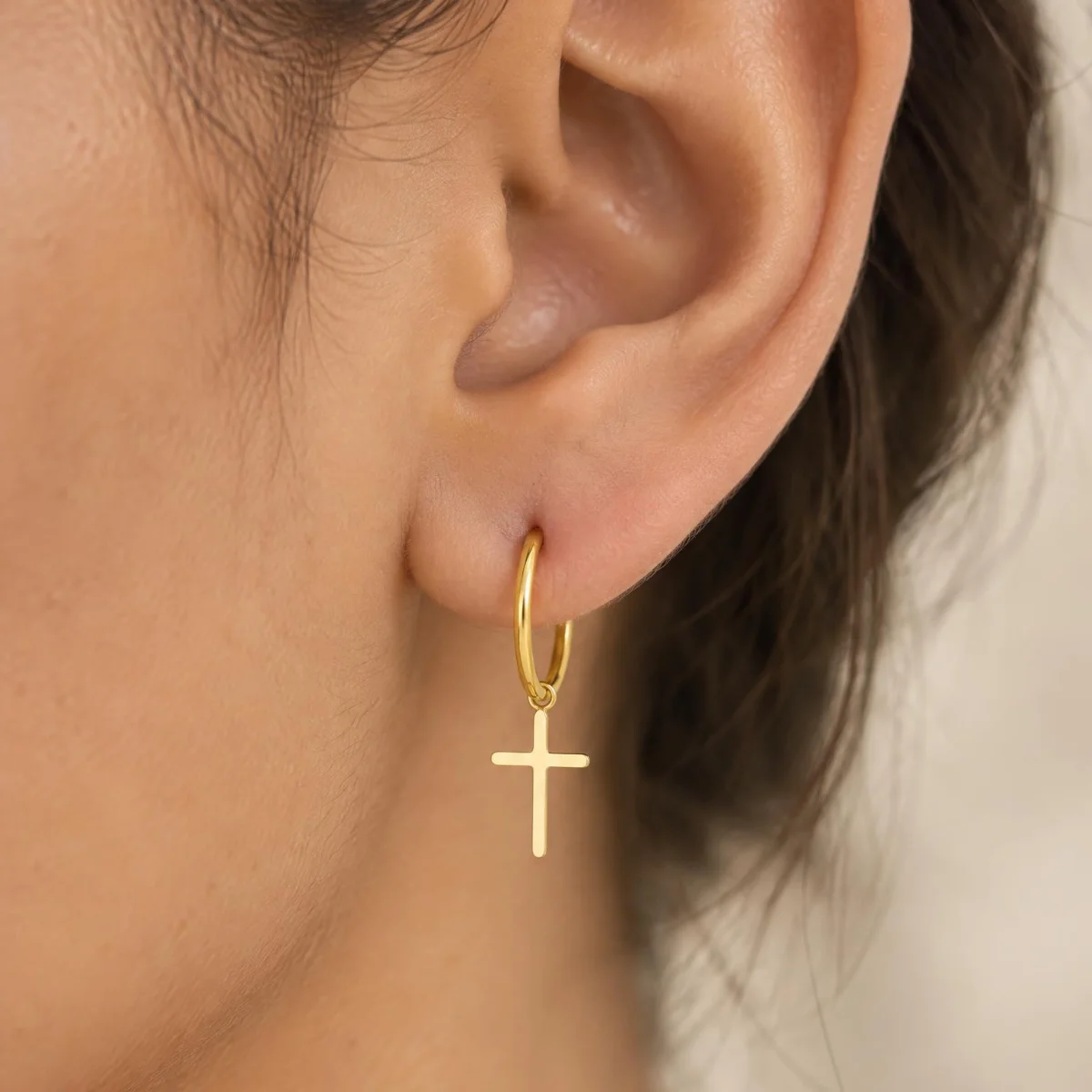 Brinco de Argola com Cruz em Ouro 18k, na orelha de uma modelo