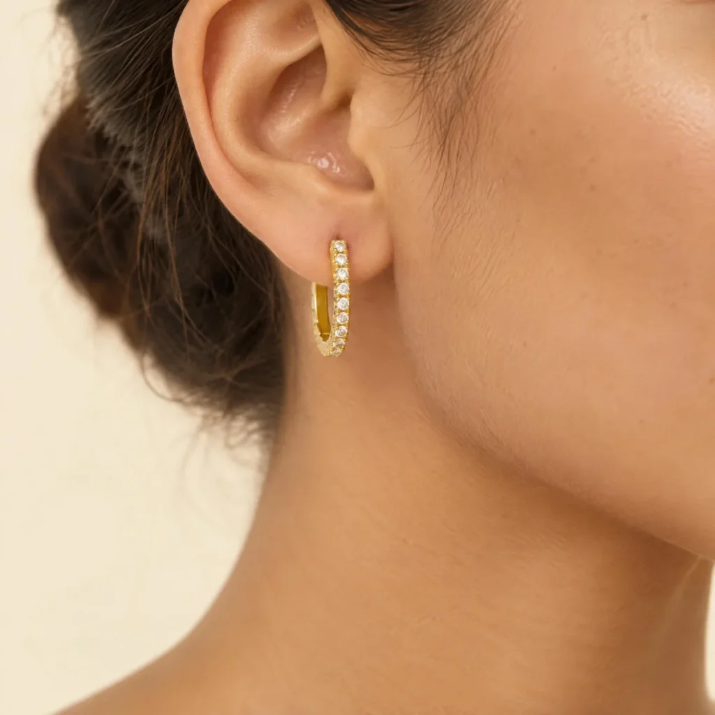 Brinco de Argola Cravejada em ouro 18k, na orelha de uma modelo