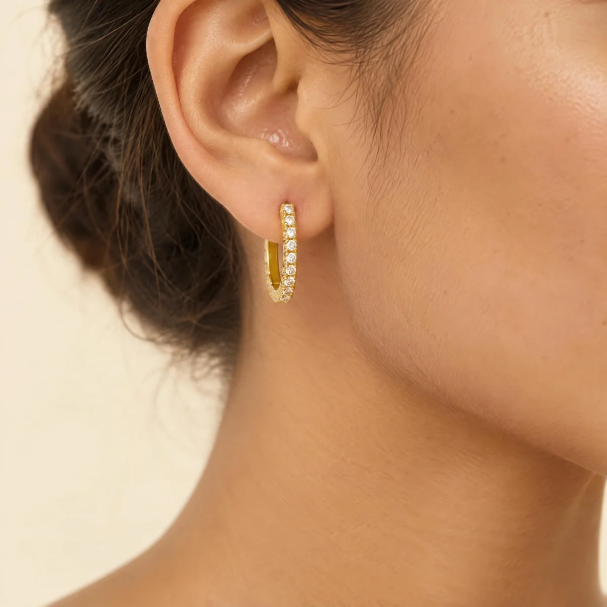 Brinco de Argola Cravejada em ouro 18k, na orelha de uma modelo