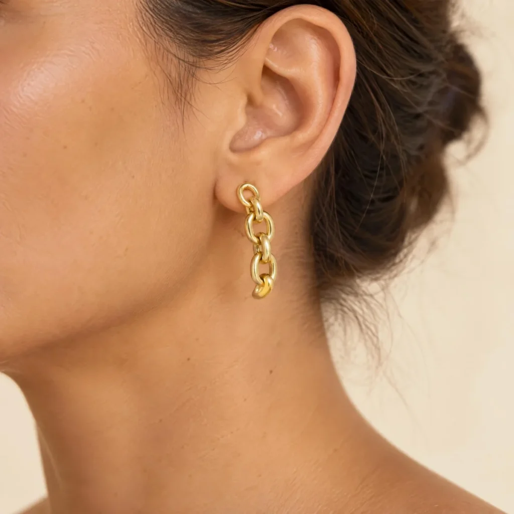 Brinco de Ouro 18k Feminino Elos Pendurados, na orelha de uma modelo