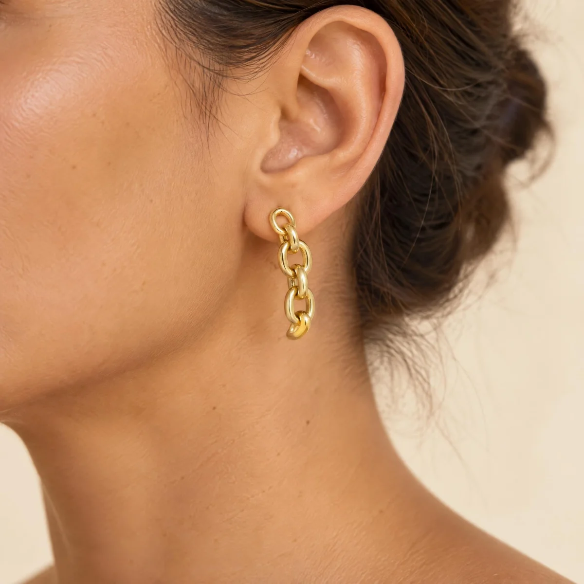 Brinco de Ouro 18k Feminino Elos Pendurados, na orelha de uma modelo