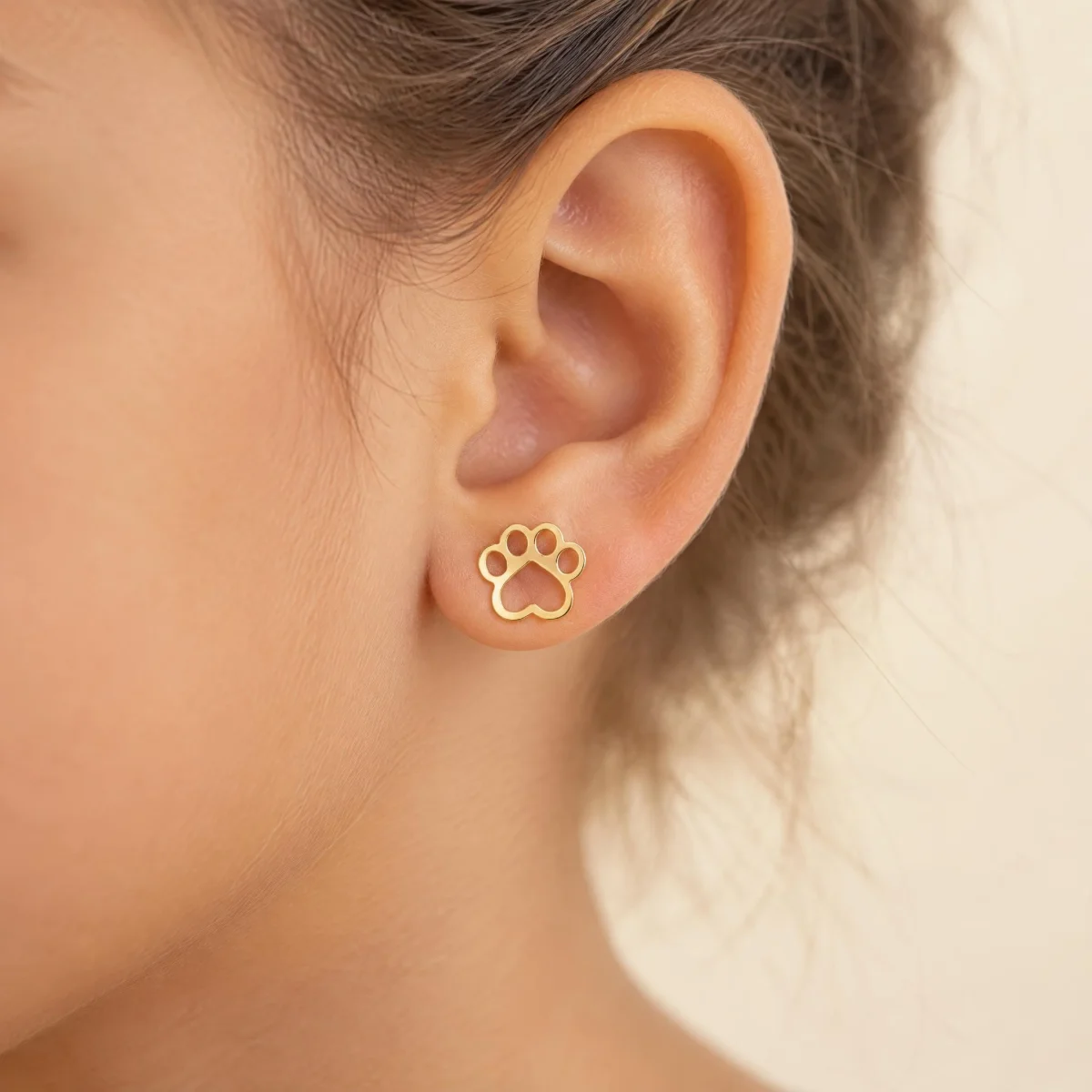 Brinco de Ouro 18k Feminino Patinha, na orelha de uma modelo
