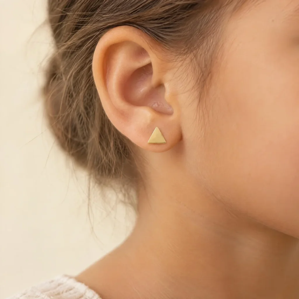Brinco de Ouro 18k Feminino Triângulo, na orelha de uma modelo