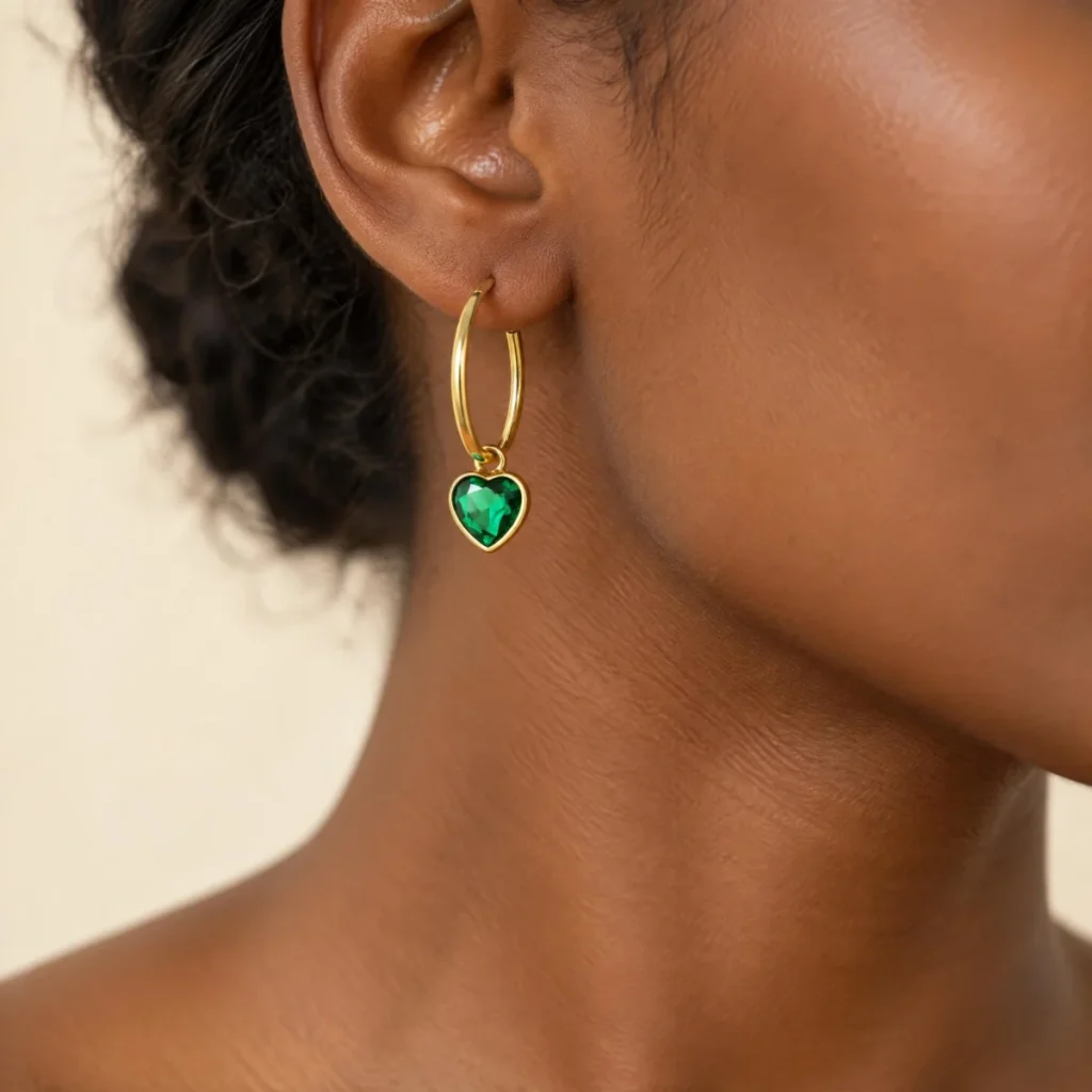 Brinco de Pedra Verde em Argola com Coração em ouro 18k, na orelha de uma modelo