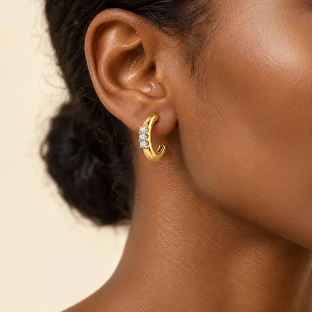 Brinco Meia Argola Cravejada em ouro 18k, na orelha de uma modelo