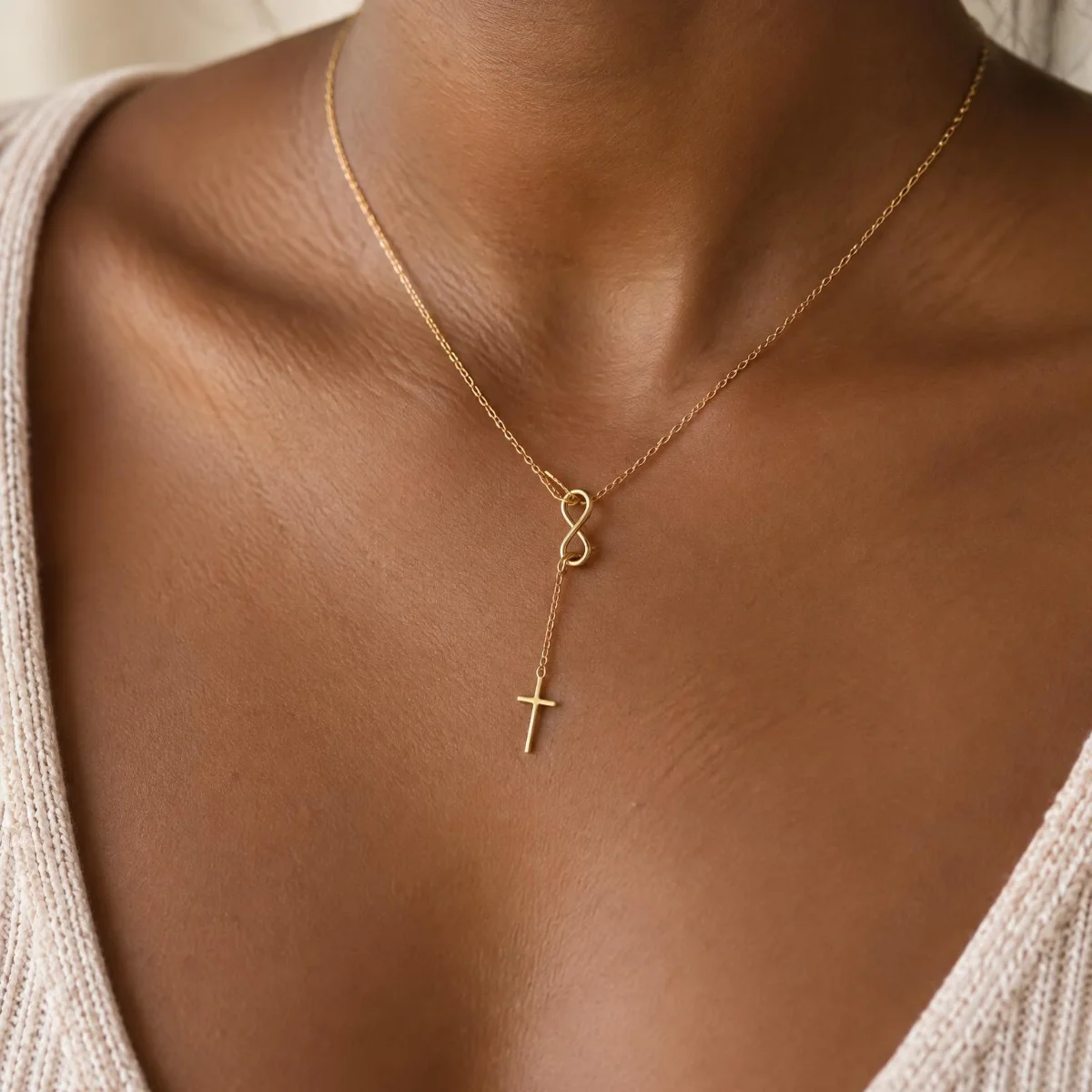Colar Fé com Cruz e Infinito em Ouro 18k, em uso por uma modelo