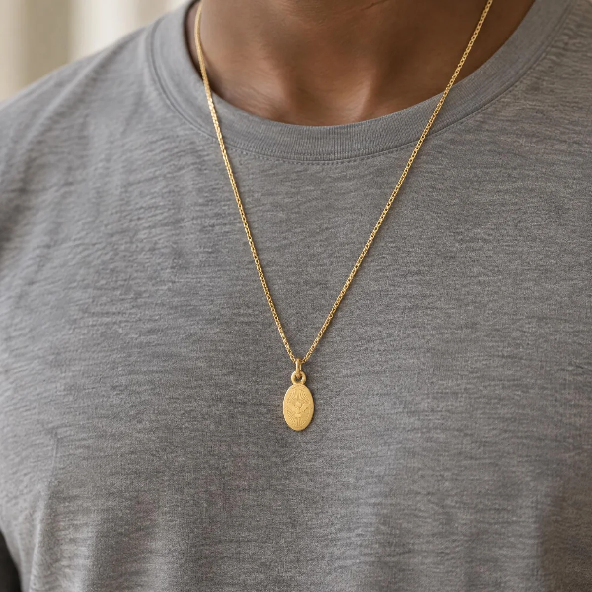 Medalha Espírito Santo Ouro 18k Oval Pequena, em uso por uma modelo