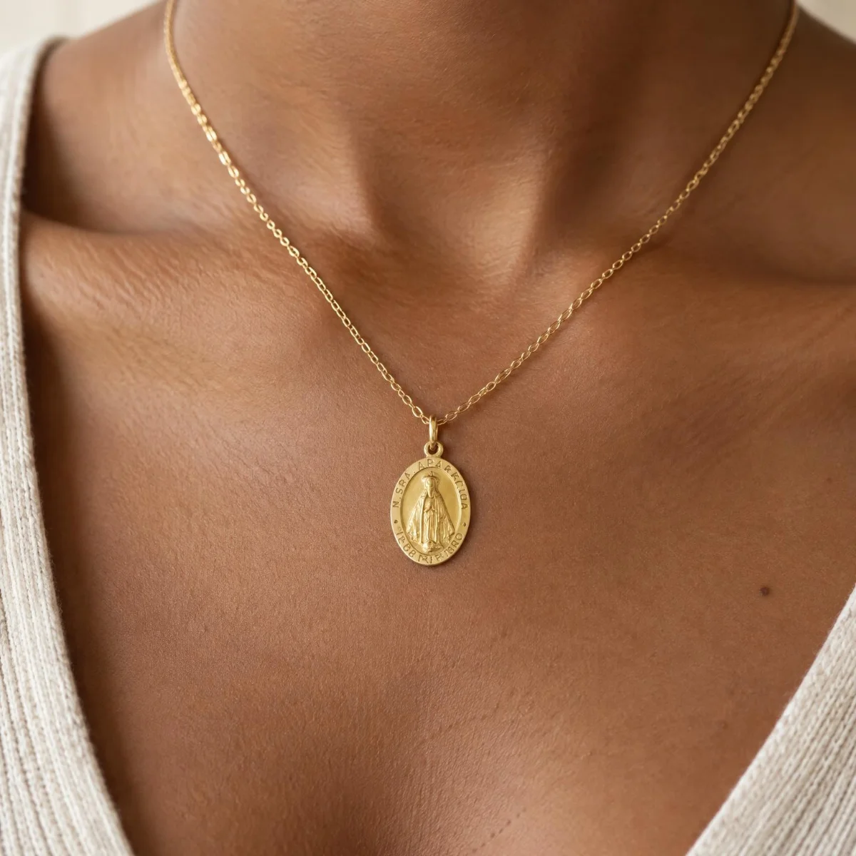 Medalha Nossa Senhora Aparecida Ouro 18k Oval com Data, em uso por uma modelo