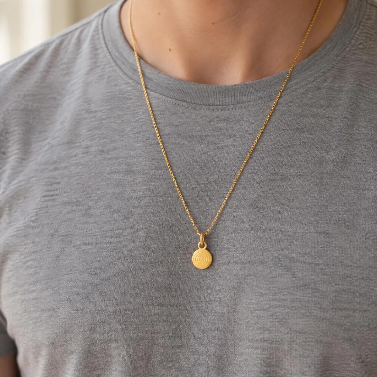 Medalha Pai Nosso Pequena em Ouro 18k, em uso por uma modelo