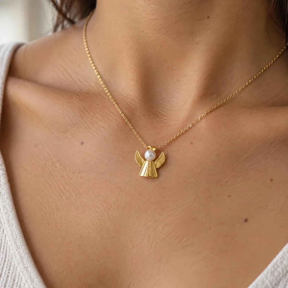 Pingente Anjo com Pérola em Ouro 18k, em uso por uma modelo