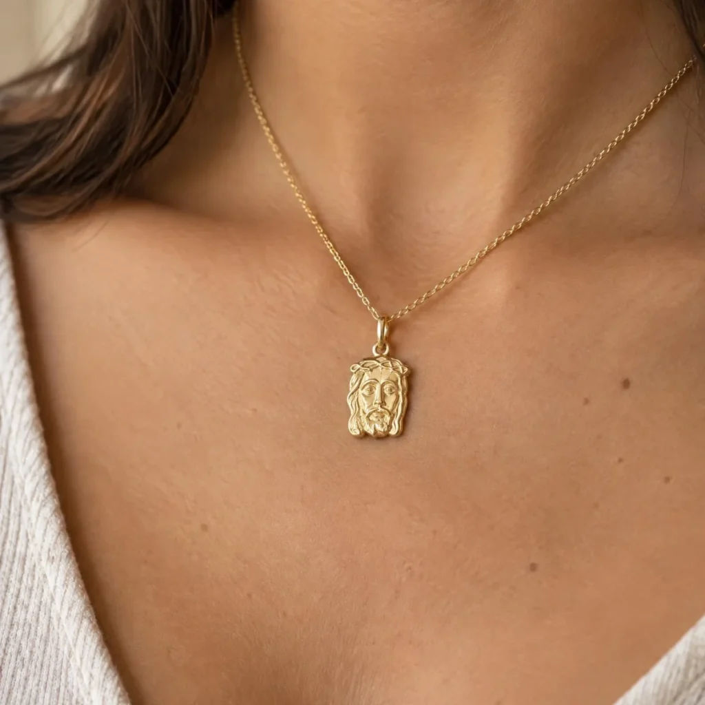 Pingente Face de Cristo Ouro 18k, em uso por uma modelo