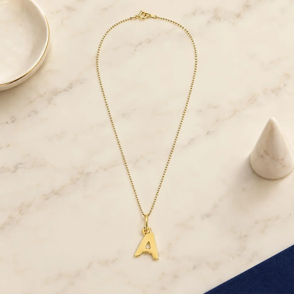Pingente Letra Ouro 18k, em foto de estúdio