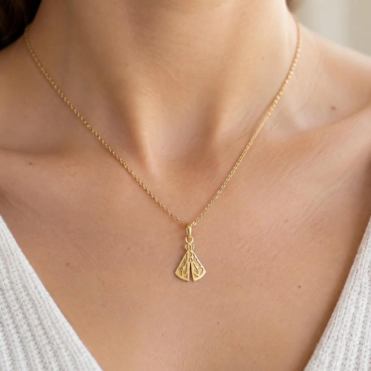 Pingente Nossa Senhora Aparecida Ouro 18k Estilizado, em uso por uma modelo